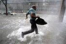  Arnold James tries to keep his feet as a strong gust nearly blows him over as he tries to make his way on foot to the Louisiana Superdome. The roof on James's home blew off, forcing him to seek shelter at the Superdome. AP Photo/Dave Martin